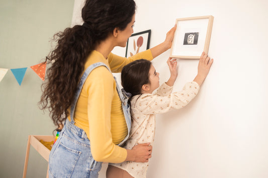 mother and child hanging up framed picture of an ultrasound