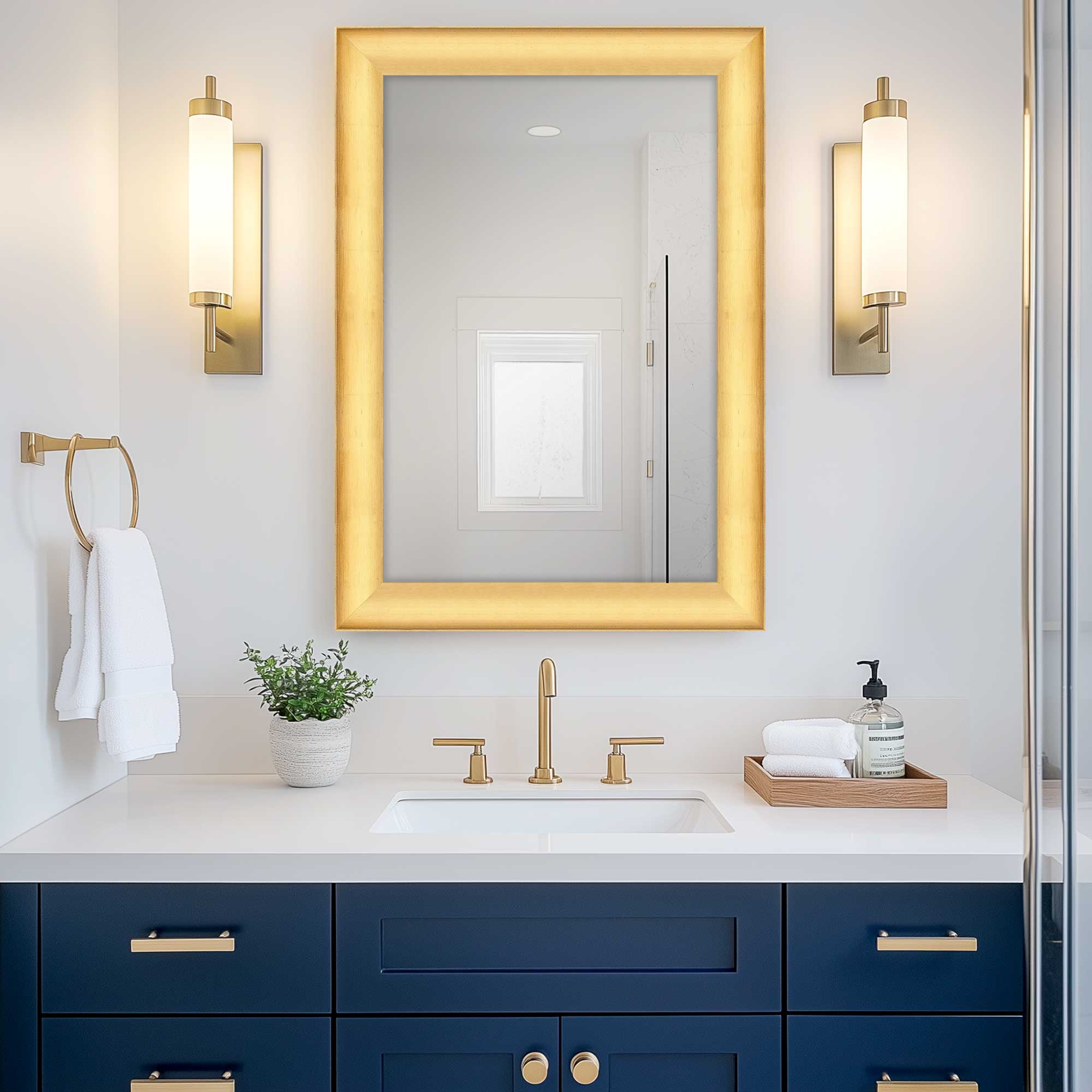 cool gold modern wall mirror hanging above bathroom sink