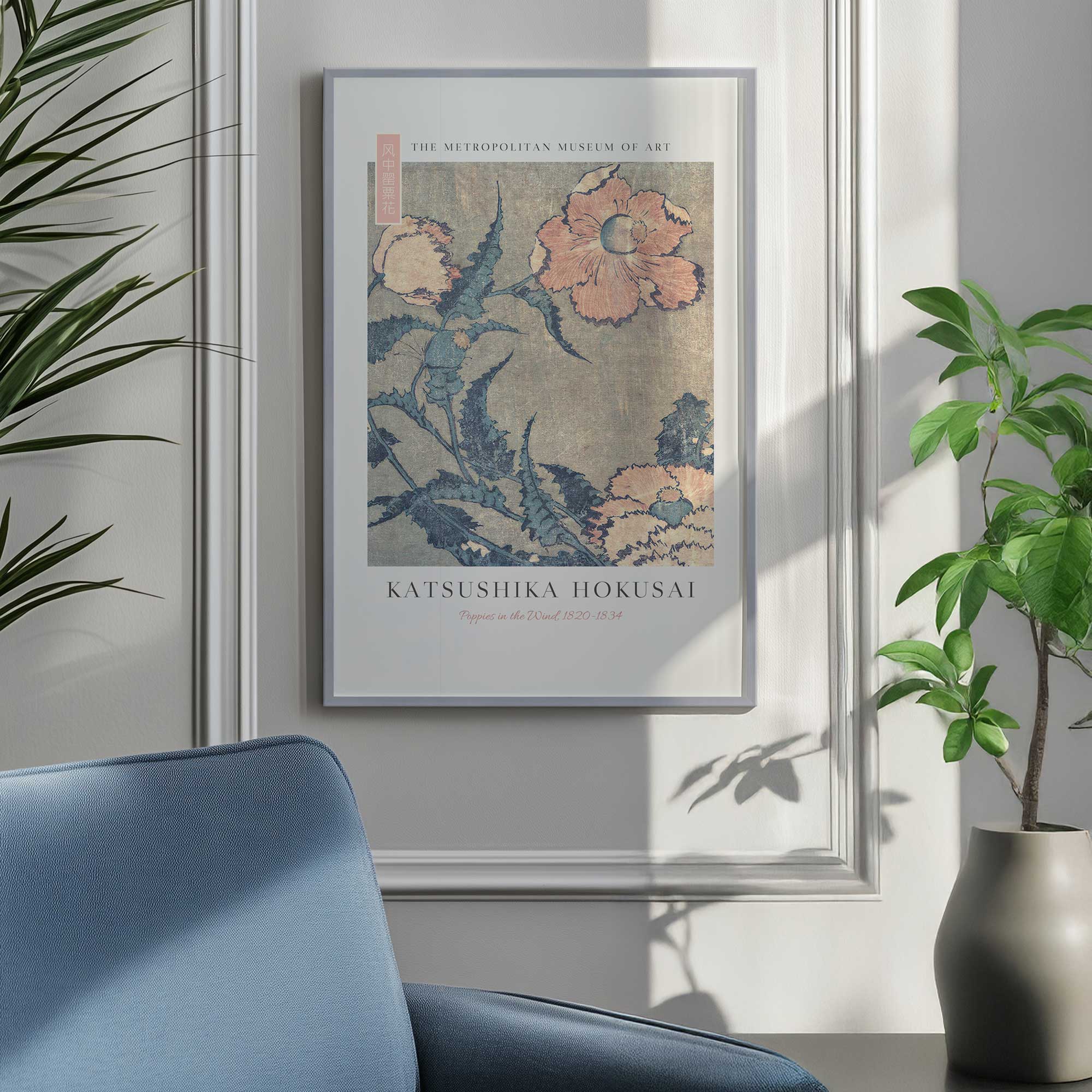 Poppies in the wind by Katsushika Hokusai in a silver frame hanging by a blue chair