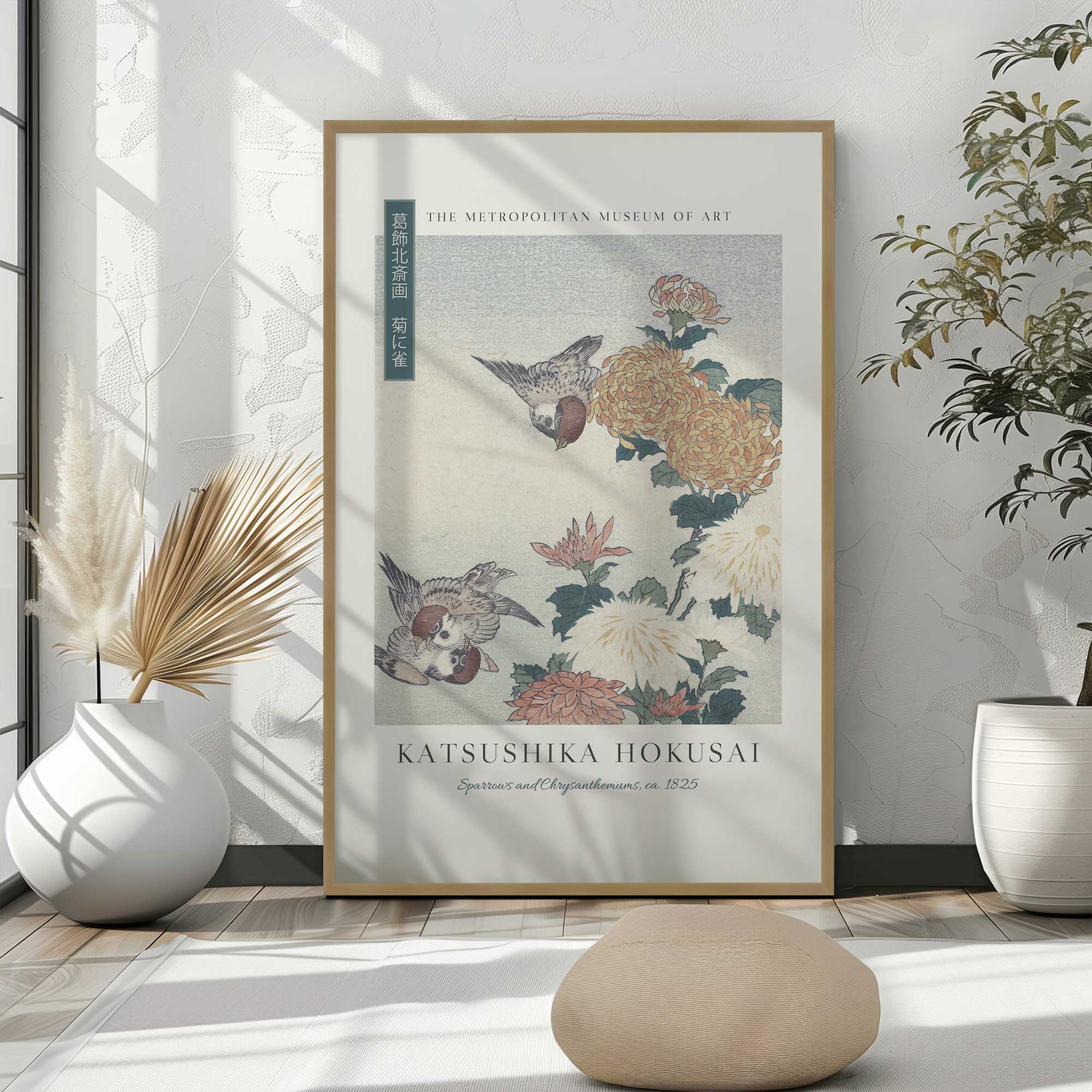 Sparrows and Chrysanthemums by Katsushika Hokusai in a gold frame leaning in against a wall in a bright room
