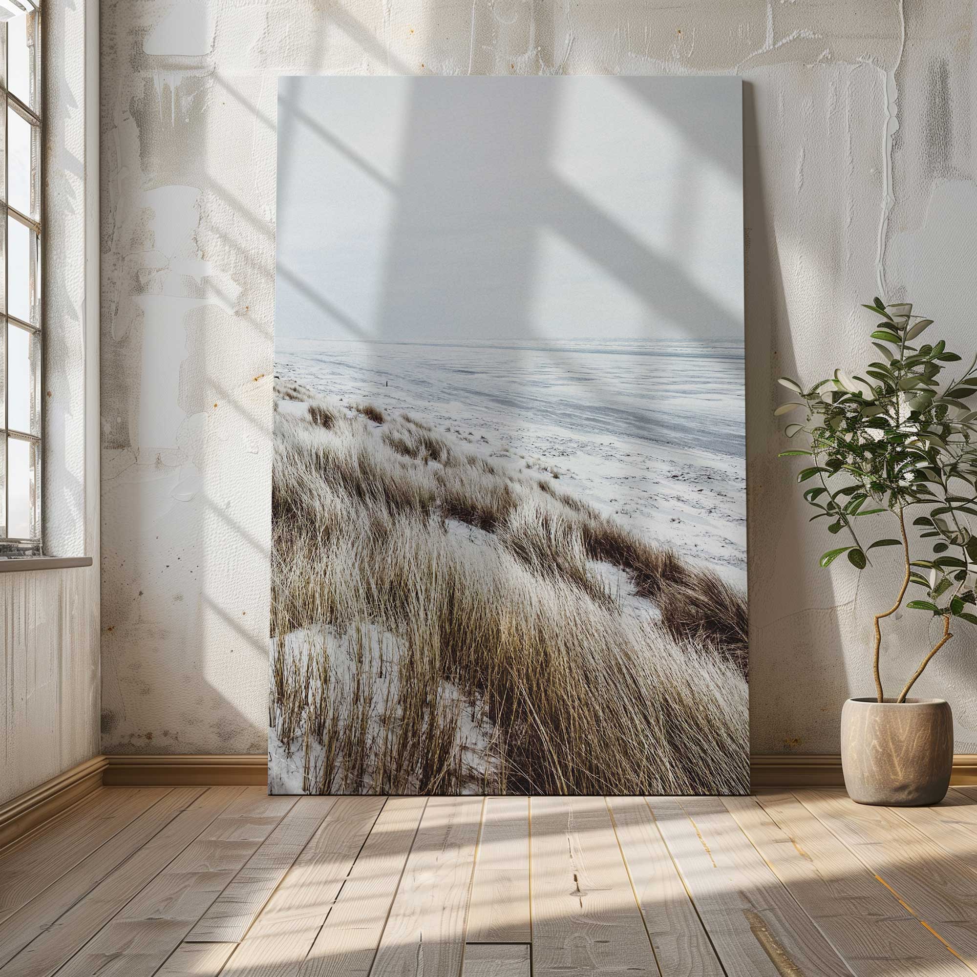 windswept shoreline canvas print of winter beach photograph leaning against a wall
