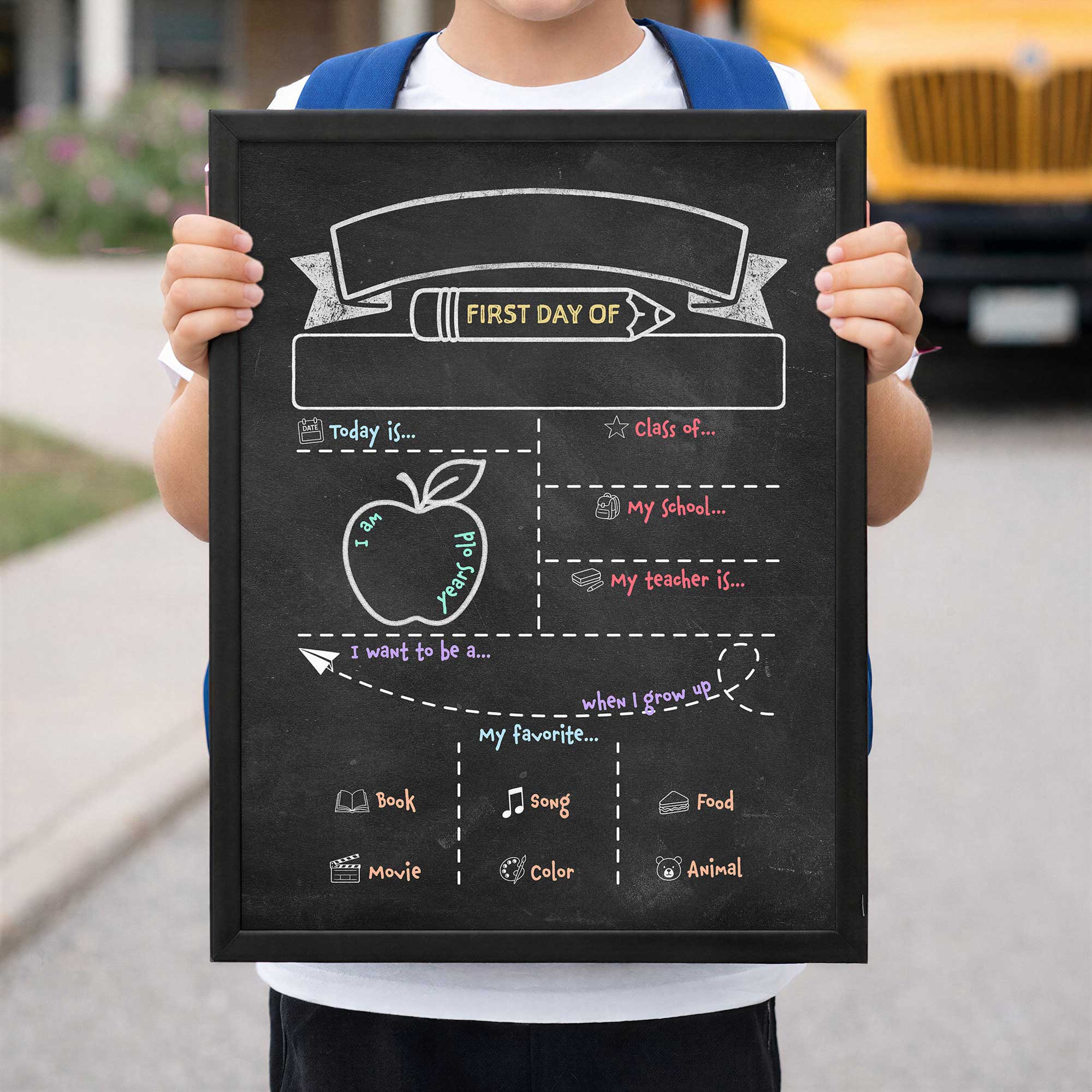 fjirst day of school dry erase board held by child in front of the school bus