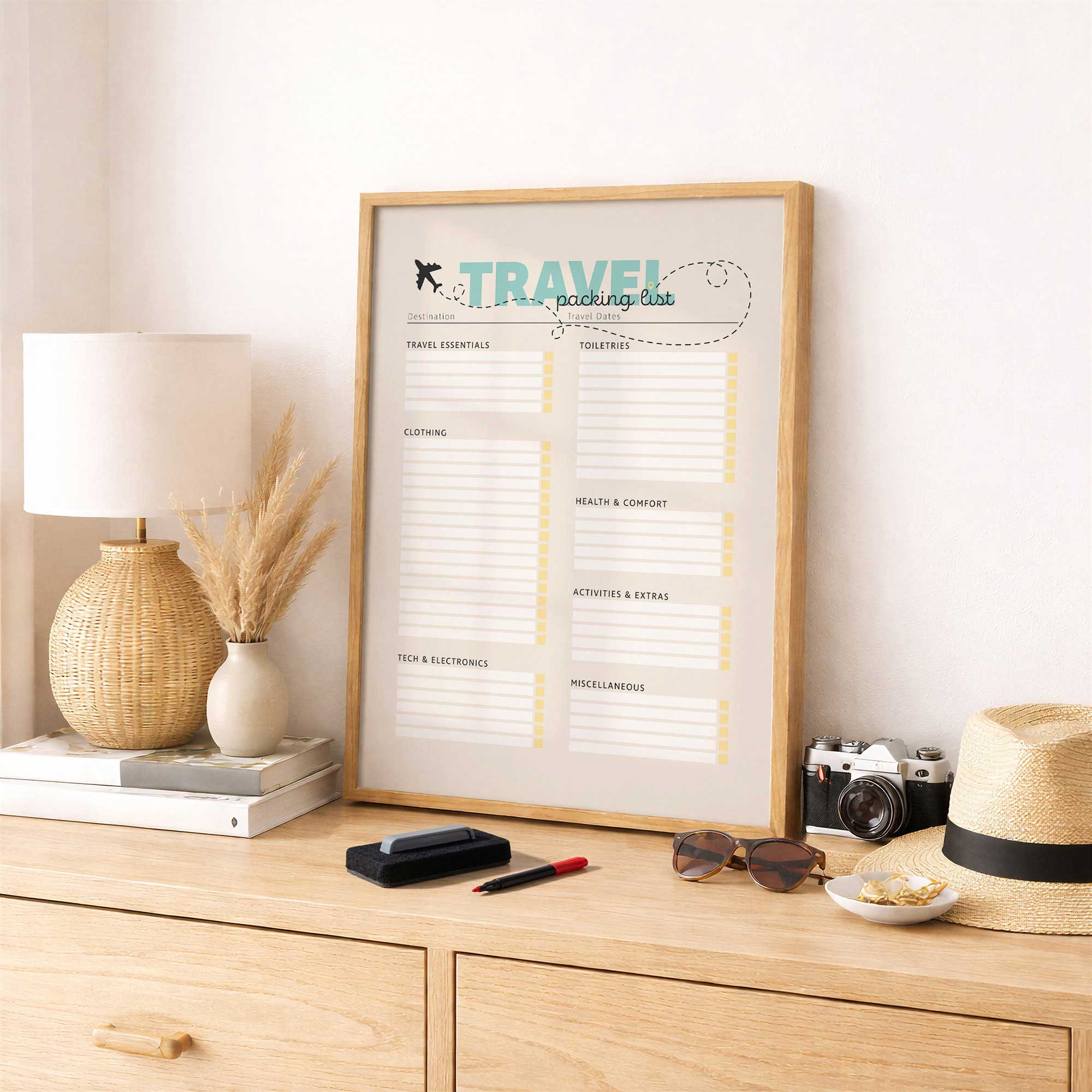 travel packing list dry erase board on a console table next to a camera