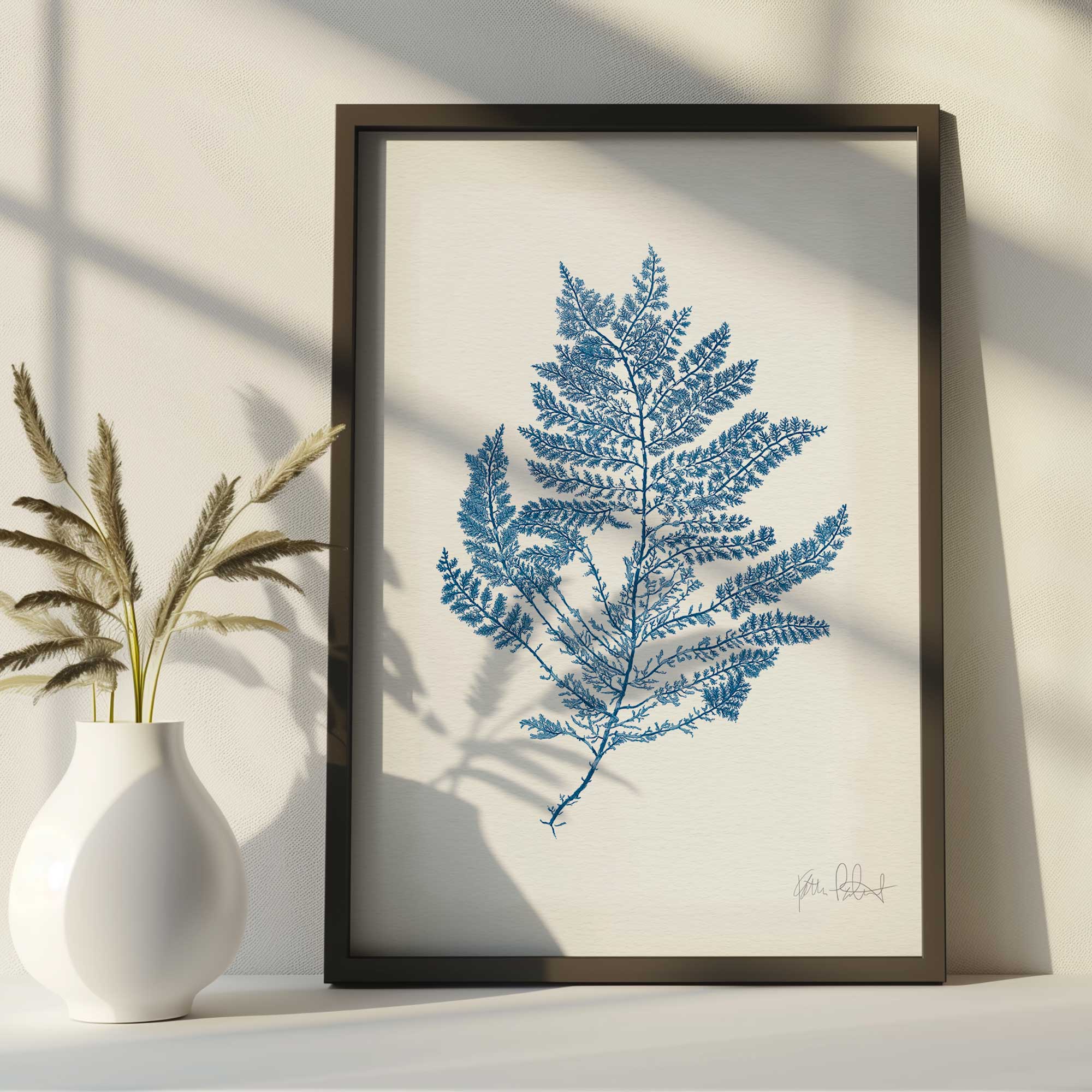 Nature's lace detailed fern drawing in a black frame on a countertop