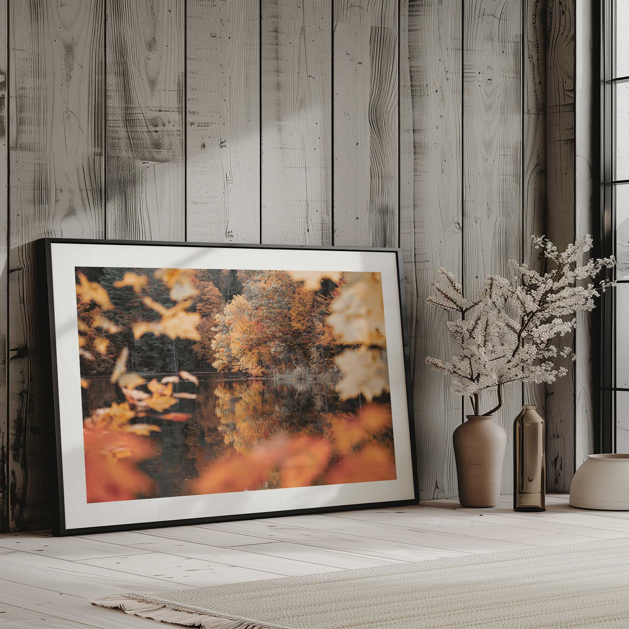 autumn's reflection print in a black frame leaning against the wall